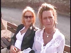 Dziewczyna na zielonym trawniku rozbiera się pod różowym parasolem